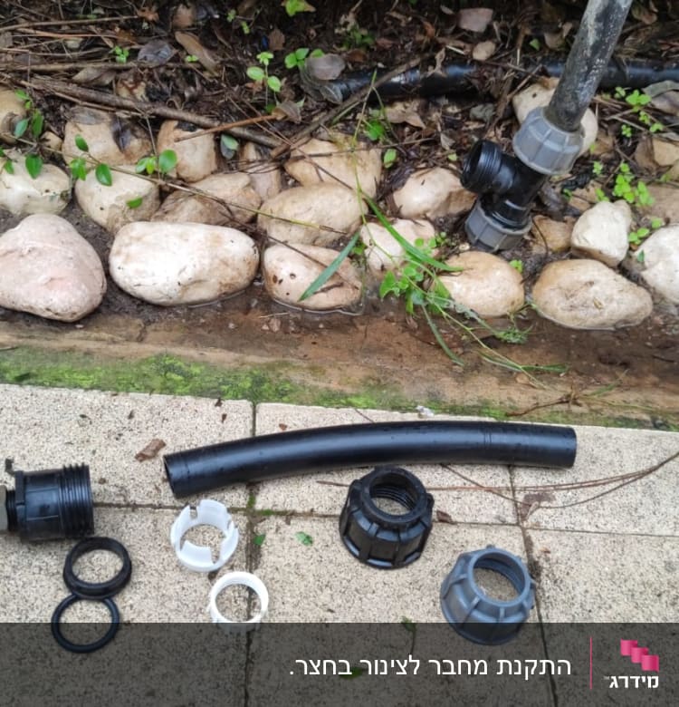 חלקי צנרת פלסטיק שחורים ואביזרי חיבור על רצפה